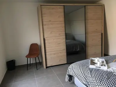 a bedroom with a large closet and a bed and a chair at Leuk overnachten in hartje Laarne, dicht bij Gent! in Laarne