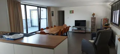 a kitchen and living room with a table and chairs at Leuk overnachten in hartje Laarne, dicht bij Gent! in Laarne