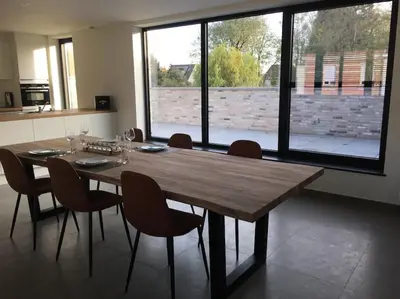 a dining room with a wooden table and chairs at Leuk overnachten in hartje Laarne, dicht bij Gent! in Laarne