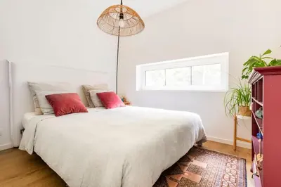 a bedroom with a large white bed with red pillows at Luxe-Avontuur in een Romantische Cabin in het Bos in Stekene