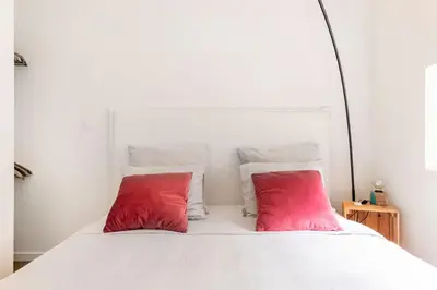 two red pillows sitting on top of a white bed at Luxe-Avontuur in een Romantische Cabin in het Bos in Stekene
