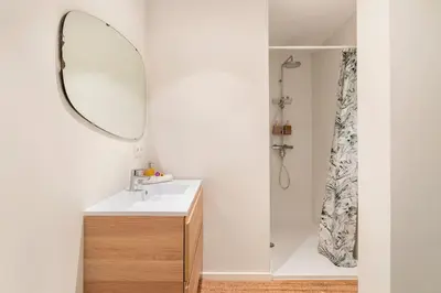 a bathroom with a sink and a shower with a mirror at Luxe-Avontuur in een Romantische Cabin in het Bos in Stekene