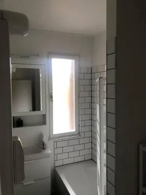 a white bathroom with a sink and a window at Quartier Diamant in Brussels