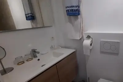 a white bathroom with a sink and a mirror at BnB Waterzicht in Wijnegem