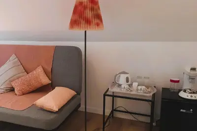 a room with a couch with a lamp and a side table at BnB Waterzicht in Wijnegem