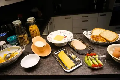 a kitchen counter with bowls of bread and other foods at BnB Waterzicht in Wijnegem