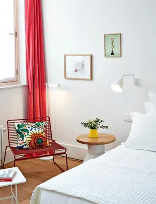a bedroom with a bed and a chair and a table at Hotel des Galeries in Brussels