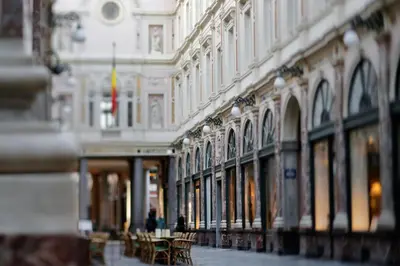 a building with tables and chairs in a street at Hotel des Galeries in Brussels