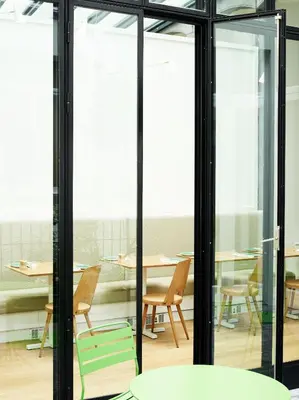 a room with glass doors and a table with chairs at Hotel des Galeries in Brussels