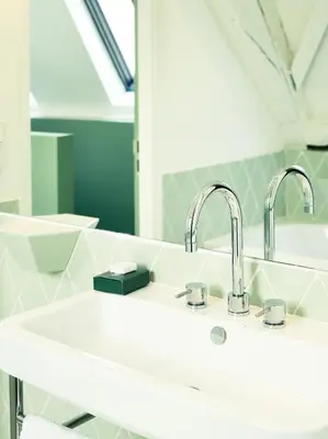 a bathroom with two sinks and a mirror at Hotel des Galeries in Brussels