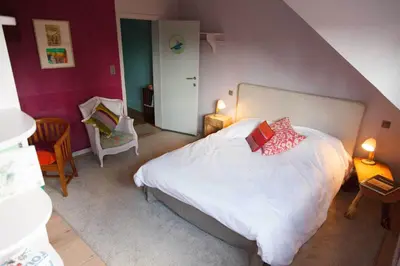 a bedroom with a white bed with two pillows on it at Guest House Les 3 Tilleuls in Brussels