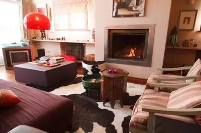 a living room with a fireplace and a couch at Guest House Les 3 Tilleuls in Brussels