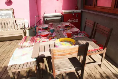 a wooden table with two chairs and a table with dishes on it at Guest House Les 3 Tilleuls in Brussels