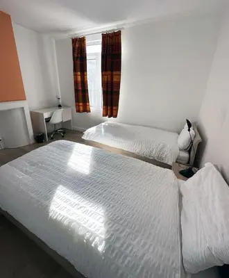 a bedroom with two twin beds and a window at Large Quiet Charming Rooms in House near Historic Gent Centre in Ghent