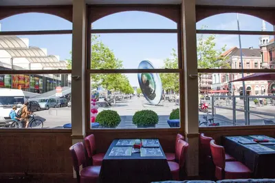 a window of a restaurant with a view of a street at Hotel New Flanders in Sint-Niklaas
