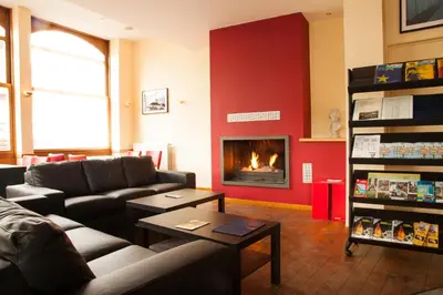 a living room with a couch and a fireplace at Hotel New Flanders in Sint-Niklaas