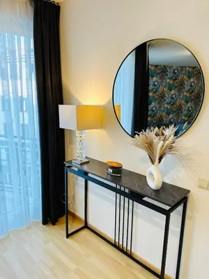 a mirror on a wall above a table with a lamp at Urbanstay Suites Apartment In Charming Sablon in Brussels