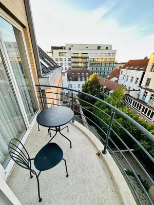 a table and chairs on a balcony with a view at Urbanstay Suites Apartment In Charming Sablon in Brussels