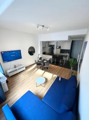 a living room with a blue couch and a table at Amazing flat-Center of Brussels in Brussels