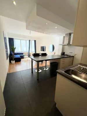 a kitchen with a table and a living room at Amazing flat-Center of Brussels in Brussels