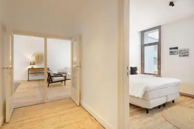 a white bedroom with a bed and a desk at The 1894 Residence by Domani Hotels in Antwerp