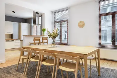 a kitchen and dining room with a wooden table and chairs at The 1894 Residence by Domani Hotels in Antwerp