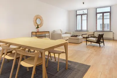a living room with a wooden table and chairs at The 1894 Residence by Domani Hotels in Antwerp