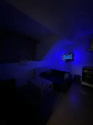 a dark room with a couch and a blue light at Elegance & Comfort Brand New Apartment near to Atomium in Brussels