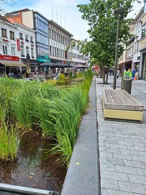 a bench sitting on the side of a city street at Huis ALNA 4 in Mechelen