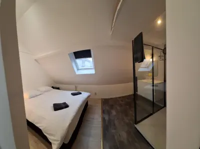 a small bedroom with a bed and a window at Huis ALNA 4 in Mechelen