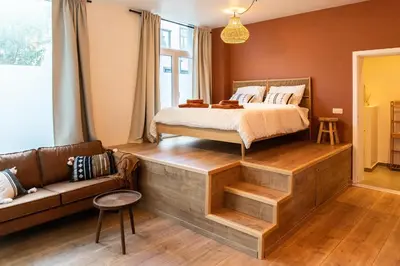 a bedroom with a bed and a couch in it at Romantische Studio in Harmoniewijk in Antwerp