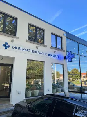 a white building with a car parked in front of it at Akuta City Flat Leuven in Leuven