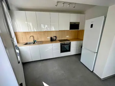 a kitchen with white cabinets and a white refrigerator at Akuta City Flat Leuven in Leuven