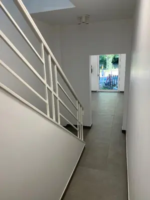 an empty hallway with stairs in a house at Akuta City Flat Leuven in Leuven