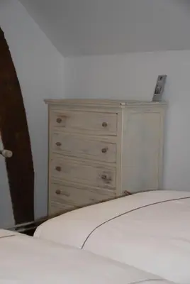 a bedroom with a dresser and a bed at The Little House in Beersel