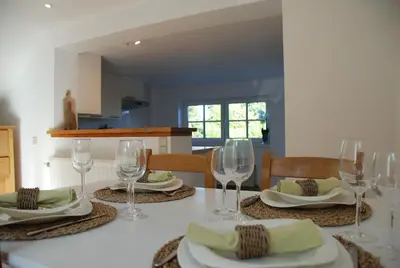 a table with wine glasses and plates on it at The Little House in Beersel