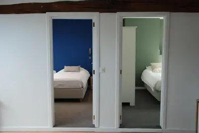 a room with two beds and a mirror at The Little House in Beersel