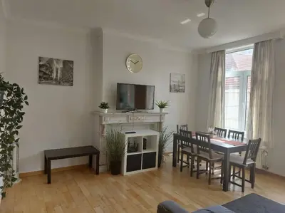 a living room with a table and chairs and a tv at Charming 1-Bedroom Apartment in Brussels