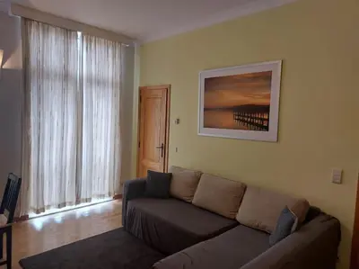 a living room with a couch and a picture on the wall at Charming 1-Bedroom Apartment in Brussels