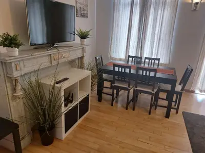 a dining room with a table and chairs and a television at Charming 1-Bedroom Apartment in Brussels