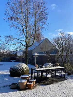 a table and chairs in a yard with snow at B&B Aline Florentine - adults only - Luxury B&B - Chambres d'Hôtes - Zimmer Frei in Kortenberg