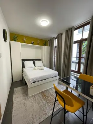 a bedroom with a bed and a table and chairs at Apartament in Brussels