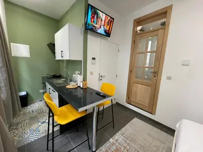 a kitchen with a table and two yellow chairs at Apartament in Brussels