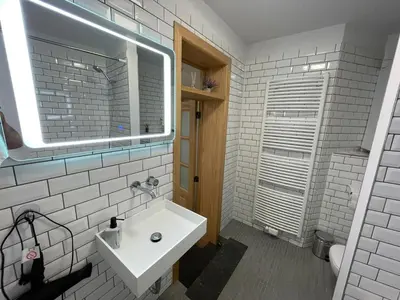 a white bathroom with a sink and a mirror at Apartament in Brussels