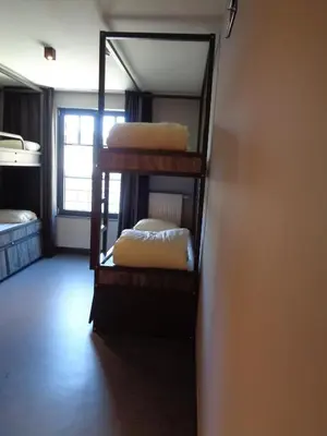 a room with three bunk beds and a mirror at Brxxl 5 City Centre Hostel in Brussels