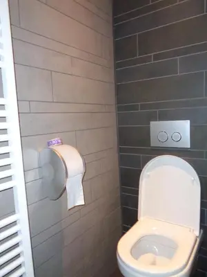 a bathroom with a toilet and a toilet paper dispenser at Brxxl 5 City Centre Hostel in Brussels
