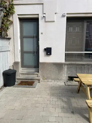 a door of a building with a picnic table in front of it at Chez Auguy et Deborah in Antwerp