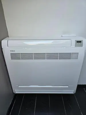 a white air conditioner sitting on a floor at Le gîte des Ambres in Denderleeuw