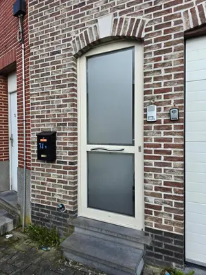 a large glass door on a brick building at Le gîte des Ambres in Denderleeuw