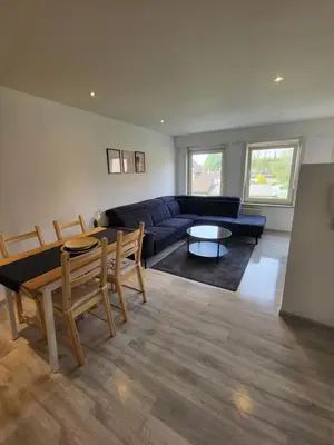 a living room with a couch and a table at Le gîte des Ambres in Denderleeuw